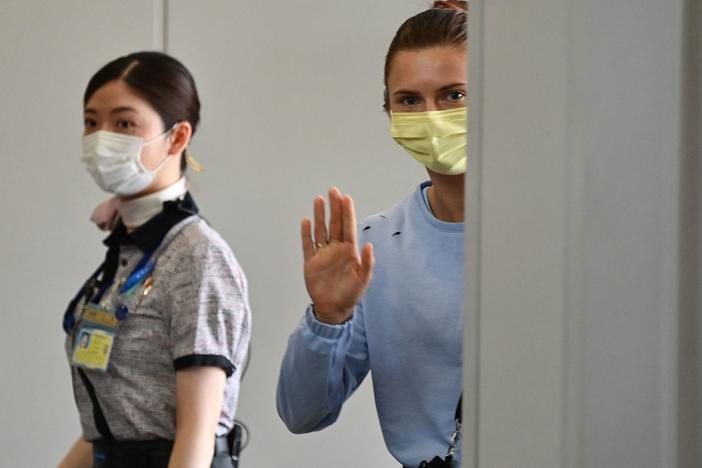 Belarus athlete Kristina Timanovskaya waves as she boards a Vienna-bound flight at Narita International Airport outside Tokyo on August 4, 2021.