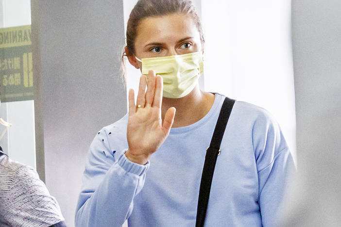 Belarusian athlete Kristina Timanovskaya received a humanitarian visa from Poland after her country's officials tried to force her to take an early flight home from the Tokyo Olympics. Here she boards a flight Wednesday to Austria at Japan's Narita international Airport.