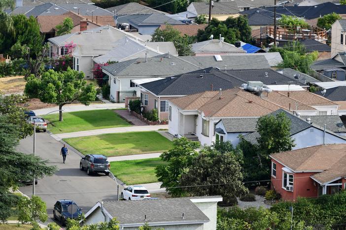 A man walks through a neighborhood of single-family homes in Los Angeles last week. The CDC announced a new temporary eviction ban a few days after the previous one expired.