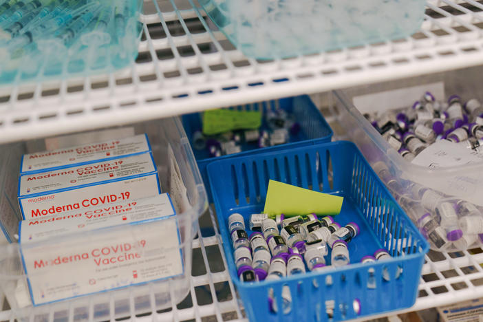 Moderna and Pfizer COVID-19 vaccines sit in a refrigerator at a mass vaccination site in June in Cranston, R.I. As demand for vaccines lags in the U.S., expiration dates loom. At the same time, lower-income countries are eager for more doses as infections rise.