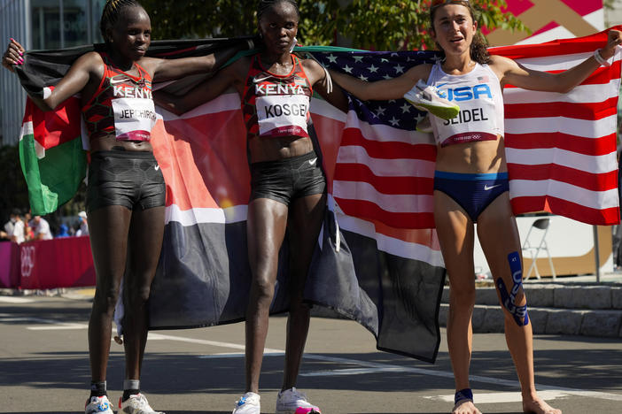 Gold medalist Peres Jepchirchir (left) of Kenya, stands with silver medalist and compatriot Brigid Kosgei, (center) and bronze medalist Molly Seidel (right) of the United States, after the women's marathon at the Summer Olympics in Sapporo, Japan.