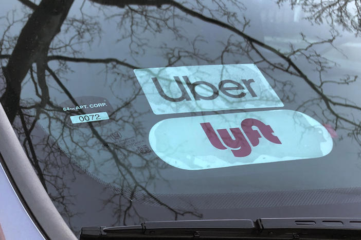 Uber and Lyft sign in windshield of car, Queens, New York.