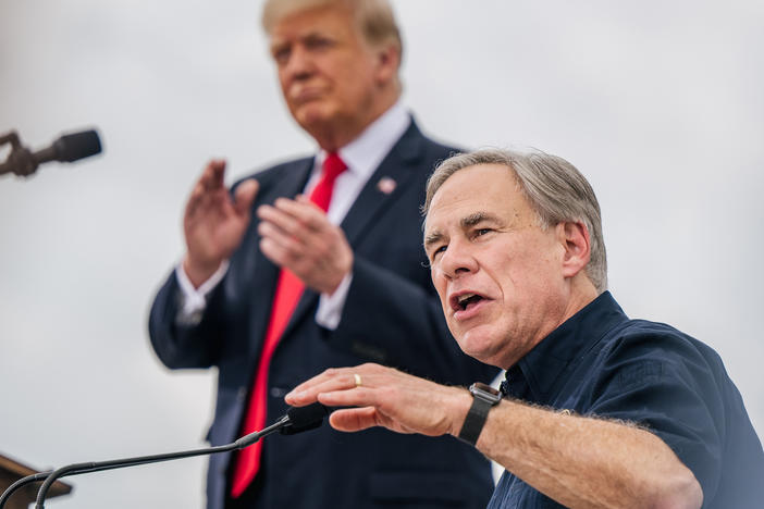 Texas Gov. Greg Abbott speaks alongside former President Donald Trump during a tour of an unfinished section of the border wall on June 30 in Pharr, Texas. Abbott says he'll continue Trump's border barrier, a pledge that is expected to help the governor in his reelection campaign.