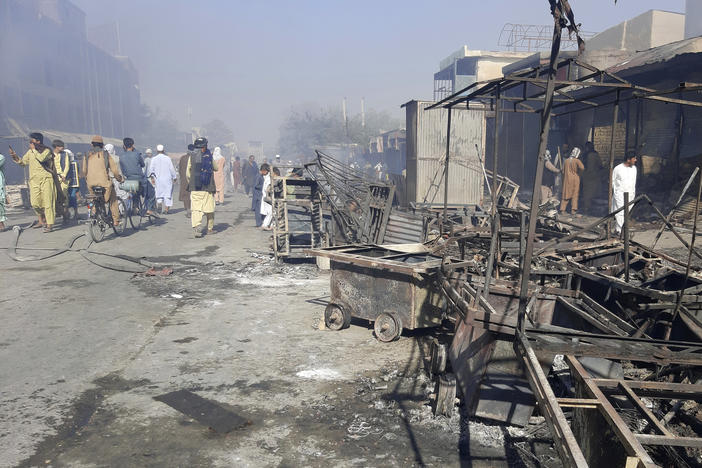 Afghans inspect damaged shops after fighting between Taliban and Afghan security forces in Kunduz city, northern Afghanistan, Sunday, Aug. 8, 2021. Taliban fighters Sunday took control of much of the capital of Kunduz province, including the governor's office and police headquarters, a provincial council member said. (AP Photo/Abdullah Sahil)