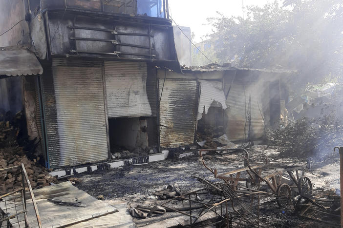 Smoke rises from damaged shops after fighting between Taliban and Afghan security forces in Kunduz city, northern Afghanistan, on Sunday, Aug. 8.