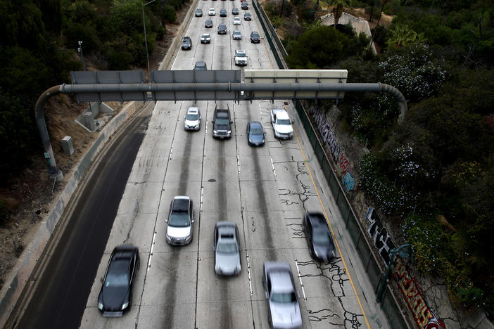 Cars drive down the 110 Freeway toward downtown Los Angeles, California in April 2021. President Biden has pledged to cut U.S. greenhouse gas emissions in half by 2030.