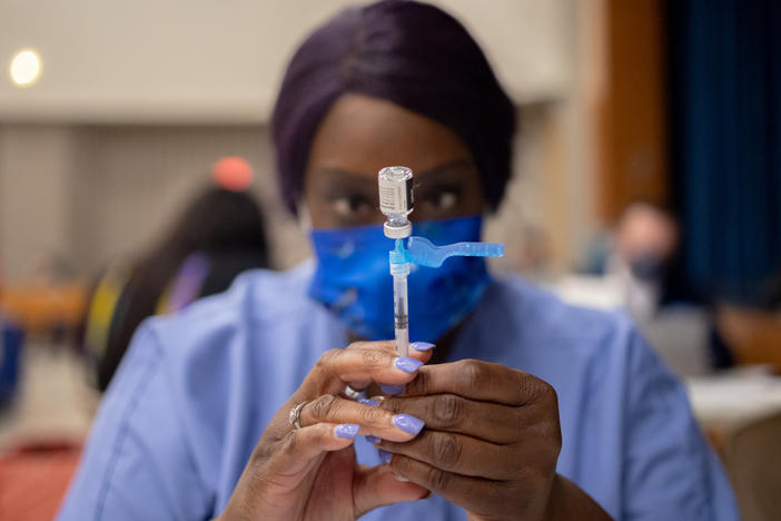 A health care worker prepares a dose of the Pfizer-BioNTech COVID-19 vaccine last week at West Philadelphia High School in Philadelphia. Dr. Anthony Fauci says he backs mandatory vaccines for teachers, citing a "critical situation" in the country.