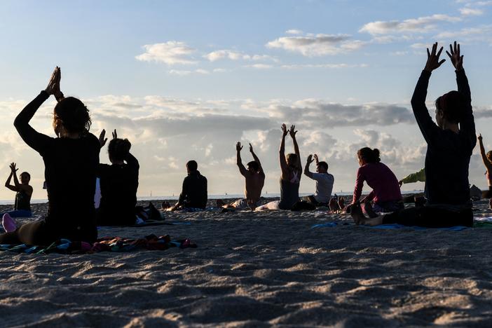 People do yoga on the beach in Miami Beach, Fla., on March 23.