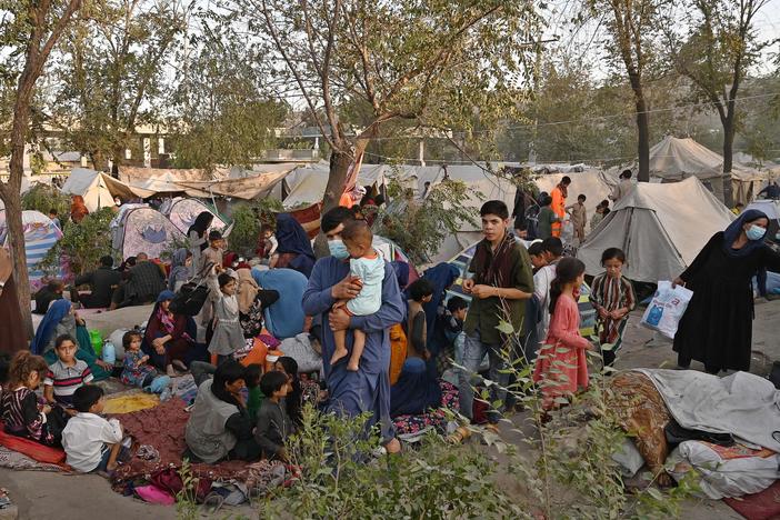 Internally displaced Afghan families, who fled from Kunduz, Takhar and Baghlan provinces due to battles between the Taliban and Afghan security forces, sit in front of temporary tents on Wednesday at Sara-e-Shamali in Kabul.