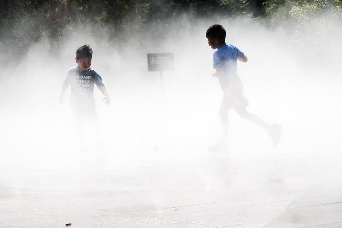 Children beat the heat Thursday in a misting pool at a park in Queens as temperatures reach into the 90s in New York City.