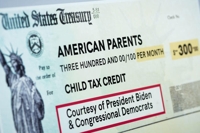 A child tax credit poster is displayed during a news conference in Washington, D.C., on July 15. Early data shows that after the child tax credit payments went out this summer, the number of households with children who experience food insufficiency dropped.