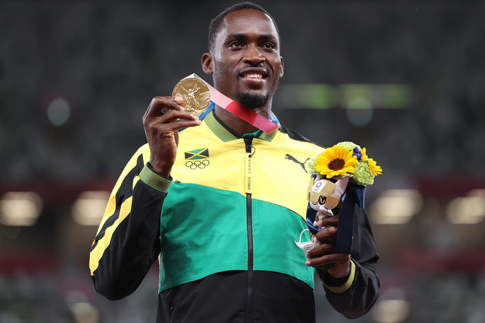 Gold medalist Hansle Parchment of Jamaica holds up his medal on the podium during the medal ceremony for the men's 110-meter hurdles on Aug. 5.