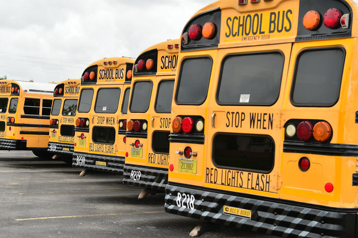 A fleet of Broward County School Buses are parked in a lot on July 21, 2020, in Pembroke Pines, Fla. Three county educators have died of complications from the coronavirus.