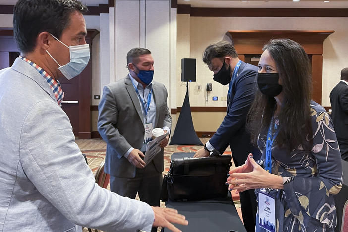 Jen Easterly, director of the Department of Homeland Security's Cybersecurity and Infrastructure Security Agency, speaks with Ohio Secretary of State Frank LaRose, left, during the summer meeting of the National Association of Secretaries of State.