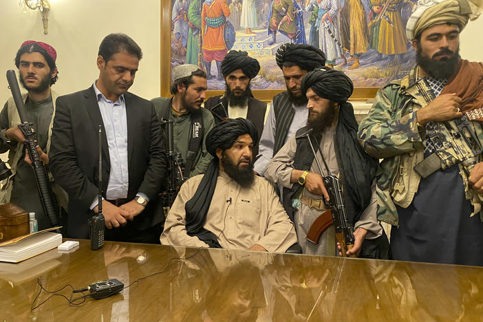 Taliban fighters take control of Afghan presidential palace in Kabul on Sunday, after President Ashraf Ghani fled the country. The person second from left is a former bodyguard for Ghani.