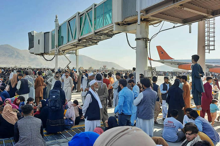 Afghans crowd the tarmac of the Kabul airport on Monday to flee the country. Thousands of people mobbed the city's airport trying to flee the group's feared hardline brand of Islamist rule.
