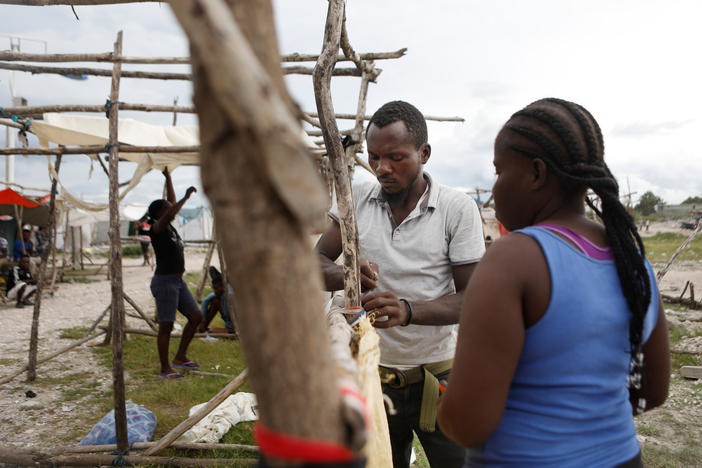 Felina Manita and her husband Jean are building a temporary home out of sticks after losing their home in Les Cayes in the earthquake on Saturday.