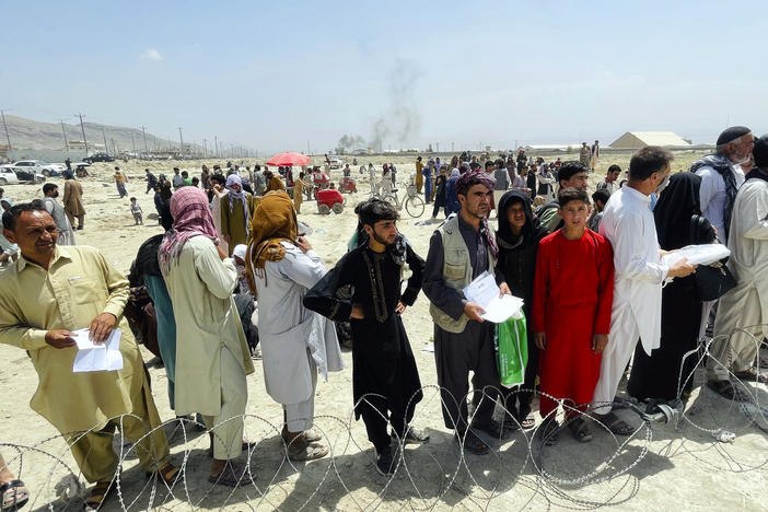 Hundreds of people gather outside the international airport in Kabul, Afghanistan, on Tuesday.