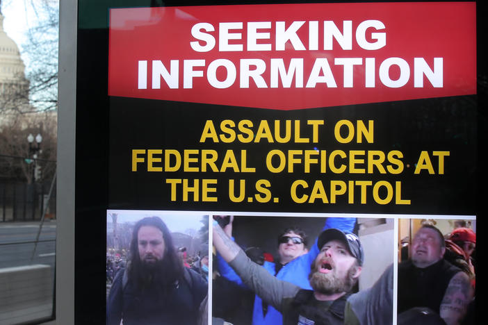 An information board shows people who are wanted by law enforcement on suspicion of assaulting federal officers at the U.S. Capitol during the Jan. 6 riot.