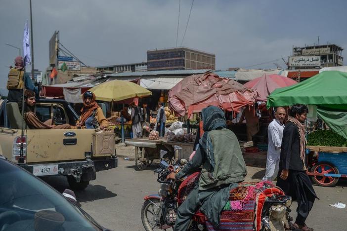 Taliban fighters on a pickup truck move around a market area Tuesday in Kabul, Afghanistan's capital.