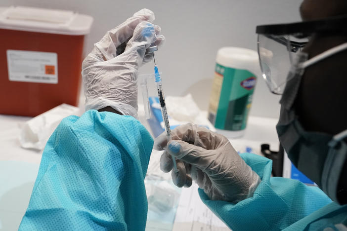 A health care worker fills a syringe with the Pfizer COVID-19 vaccine in July in New York. U.S. officials are recommending that Americans get COVID-19 booster shots to shore up their protection amid the surging delta variant and evidence the vaccines' effectiveness is falling.