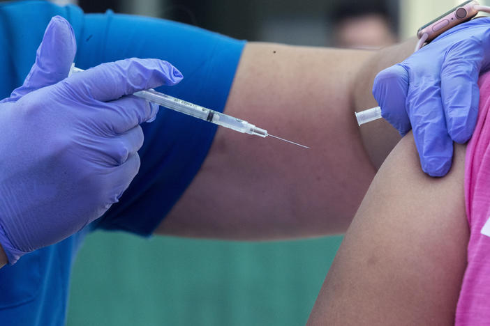 RN Amy Berecz-Ortega, left, inoculates a woman at a COVID-19 vaccine event on Tuesday in Los Angeles, Calif.