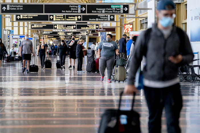 Mask-wearing travelers head through Reagan National Airport in Arlington, Va., in May. More than 70% of reports to the FAA of unruly passengers this year were related to people failing to comply with mask mandates and causing a disruption as a result.