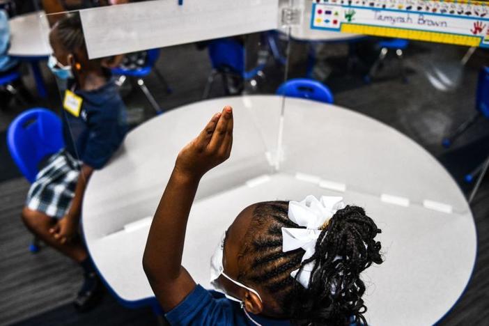 Student wear facemasks as they attend their first day in school after summer vacation at the St. Lawrence Catholic School north of Miami on Wednesday.