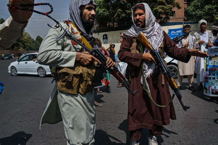 Taliban fighters mobilize to control a crowd during a rally for Afghanistan's independence day in Kabul on Aug. 19. The Taliban seized control of the city this week, effectively capturing the country in a matter of weeks.