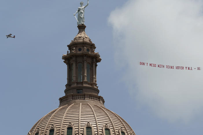 A plane pulls the message 'Don't Mess with Texas Voter Y'all' over the Texas Capitol on July 13 in Austin, Texas. Democrats left the state to block sweeping new election laws and began to return this week.