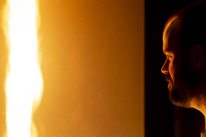 Jason Forthofer, mechanical engineer at the Missoula Fire Sciences Laboratory, looks into a fire whirl he generated to demonstrate how fire whirls and fire tornadoes form in wildland fires.