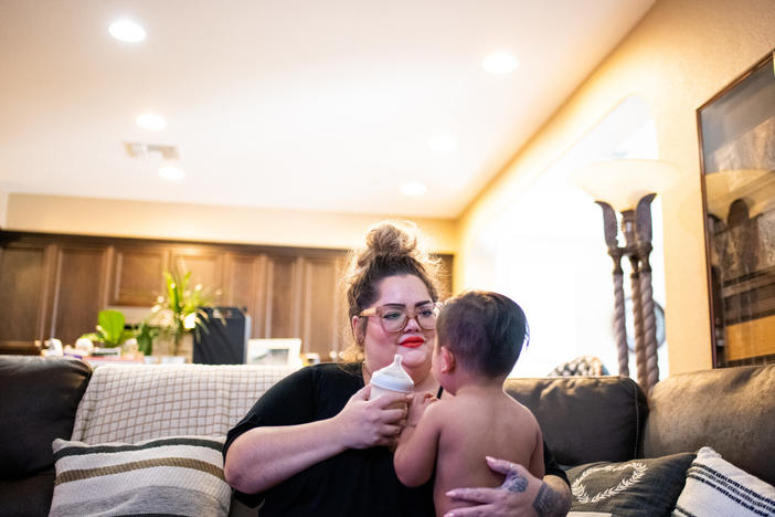 Johnson gives River a bottle in her home in Discovery Bay. Family members spent isolation together there this summer, after getting sick with COVID-19. Everyone has since recovered.