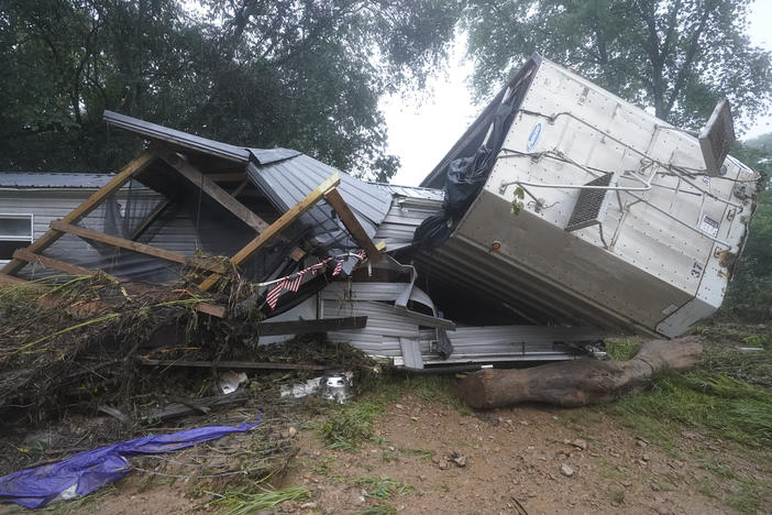 A mobile home and a truck trailer sit near a creek Sunday after they were washed away by flood waters the day before in McEwen, Tenn. Heavy rains caused flooding in middle Tennessee and have resulted in multiple deaths as homes and rural roads were washed away.