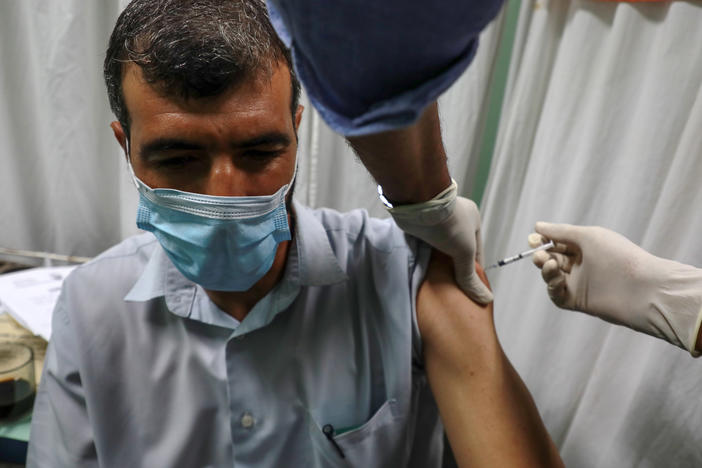 A Palestinian medic administers a dose of the Pfizer-BioNTech COVID vaccine during an inoculation campaign at a medical center in Gaza City on Aug. 23.