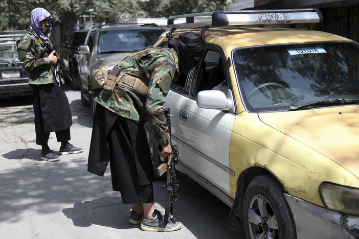 Taliban fighters search a vehicle at a checkpoint on the road in the Wazir Akbar Khan neighborhood in the city of Kabul, Afghanistan in August.