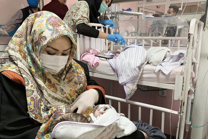 An Afghan woman feeds a newborn rescued and brought to Ataturk National Children's Hospital in Kabul in May 2020 after gunmen attacked a maternity ward operated by Doctors Without Borders. The nonprofit runs clinics and hospitals in parts of the country — and is continuing its work following the Taliban takeover.