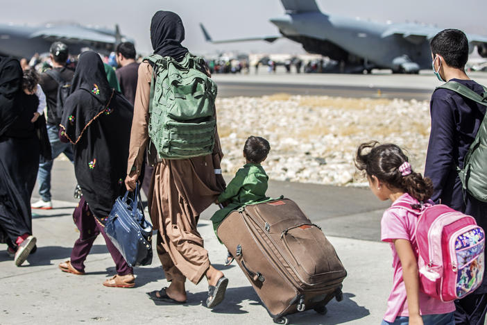 Families walk toward their flight during evacuations at Hamid Karzai International Airport in Kabul, Afghanistan, on Tuesday.