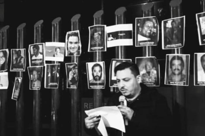 Journalist and activist Gildo Garza, right, reads the names of murdered journalists at a demonstration outside the federal attorney general's office in Mexico City.