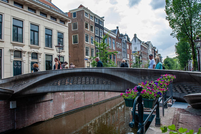 The almost 40-foot 3D-printed pedestrian bridge designed by Joris Laarman and built by Dutch robotics company MX3D has been opened in Amsterdam six years after the project was launched. The bridge, which was fabricated from stainless steel rods by six-axis robotic arms equipped with welding gear, spans the Oudezijds Achterburgwal in Amsterdam's Red Light District.