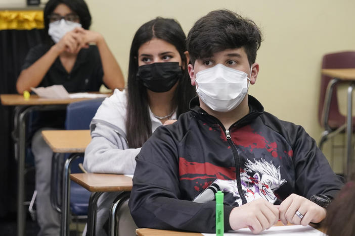 Students sit in an algebra class at Barbara Coleman Senior High School on the first day of school on Monday in Miami Lakes, Fla. Miami-Dade County public schools require students to wear a mask to prevent the spread of COVID-19.