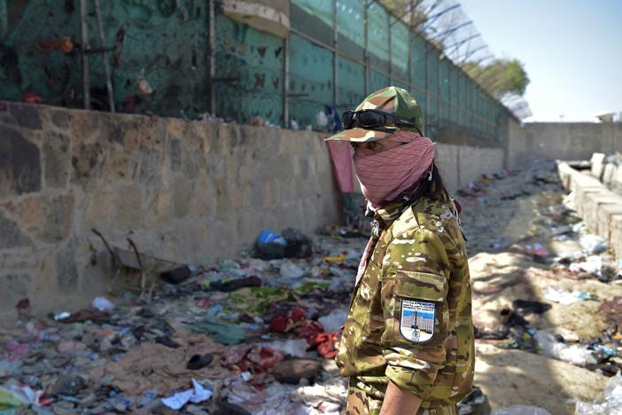 A Taliban fighter stands guard Friday at the site of the bombing that killed scores of people, including 13 U.S. troops, near the airport in Kabul. The U.S. is blaming ISIS-K for Thursday's attack.