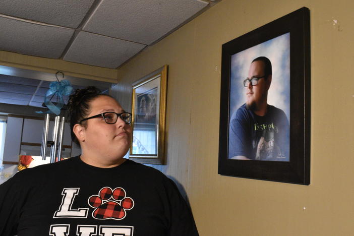 Stephanie Rimel looks at a photo of her brother Kyle Dixon, 27, who died of COVID-19 on Jan. 20. She says that during his illness and after his death, some people made insensitive comments or denied the pandemic's reality.