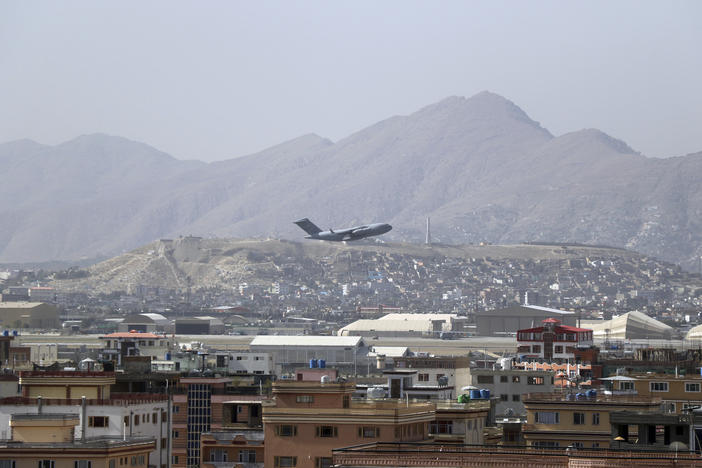 A U.S. military aircraft takes off at the Hamid Karzai International Airport in Kabul, Afghanistan, Saturday. President Biden warned another attack at the airport is "highly likely."