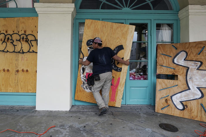 In preparation of Hurricane Ida, a workers attach protective plywood to windows and doors of a business in the French Quarter in New Orleans on Saturday.