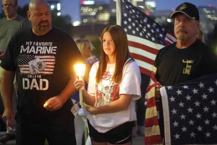 Sydney Robison, center, looks on during a vigil for U.S. Marines Staff Sgt. Taylor Hoover Sunday in Salt Lake City. Hoover was among the 13 U.S. troops killed in a suicide bombing at Kabul airport.
