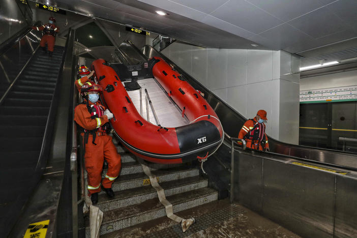 Rescuers carry a boat into the subway in Zhengzhou, China, in July after flash floods trapped passengers underground.