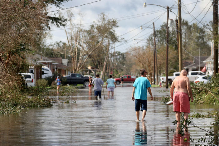 Residents walk down a flooded residential street in the aftermath of Hurricane Ida on Monday in Norco, La. Ida made landfall on Sunday as a Category 4 storm southwest of New Orleans.