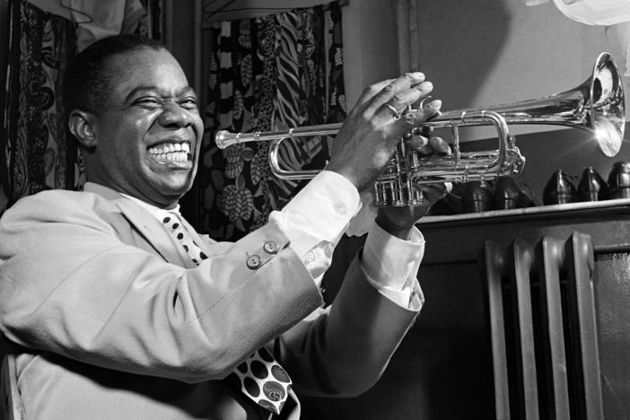 American jazzman Louis Armstrong plays trumpet in his dressing room before a show in 1947 in a New York jazz cabaret. Hurricane Ida destroyed the Karnofsky Shop in New Orleans, which was a formative influence on Armstrong's musical life.