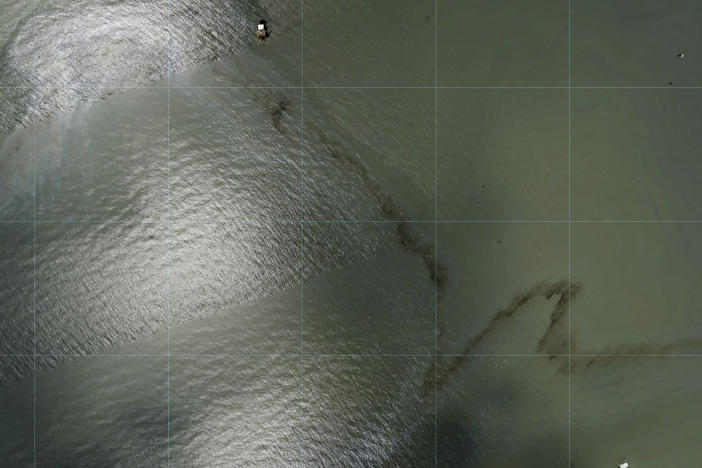 Photos captured by National Oceanic and Atmospheric Administration aircraft Tuesday, Aug. 31, 2021 and reviewed by The Associated Press show a miles long black slick floating in the Gulf of Mexico near a large rig marked with the name Enterprise Offshore Drilling.