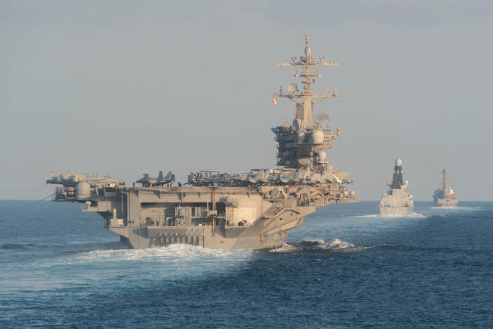 The aircraft carrier USS Abraham Lincoln (left) passes through the Strait of Hormuz in November 2019.